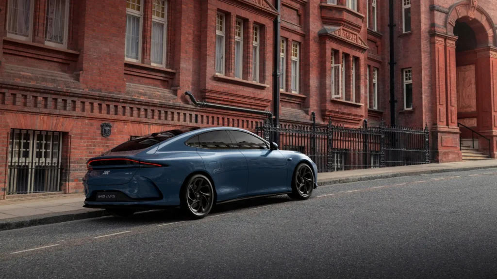 Blå sedan parkert ved en høy, rød murbygning.