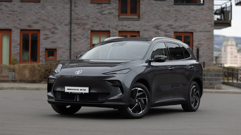 Svart elbil parkert foran en moderne murbygning.